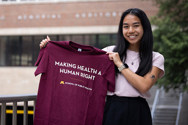 Student Tessa Jester hold SPH branded t-shirt and smiling.